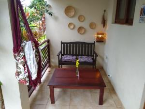 a room with a bench and a table and a window at Apto Pipa Beleza Spa Resort in Pipa