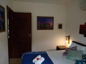 a bedroom with a bed with two rolled towels on it at Apto Pipa Beleza Spa Resort in Pipa