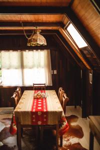 a dining room with a table and chairs and a chandelier at Chalé do Vale Encantado in Campos do Jordão