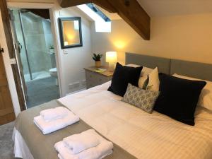 a bedroom with a large bed with towels on it at Little Coombe, Bookham Court in Dorchester
