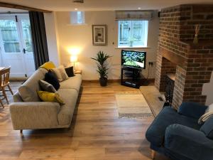 a living room with a couch and a fireplace at Little Coombe, Bookham Court in Dorchester