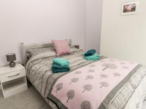 a bedroom with a bed with a pink comforter at Scarborough Cottage in Great Driffield