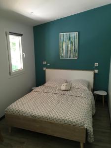 a bedroom with a bed with a blue wall at Maison & studio 14 pers avec piscine privée sécurisée in Sampzon +74 photos