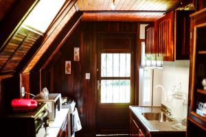 a kitchen with a window and a sink and a door at Chalé do Vale Encantado in Campos do Jordão +59 photos