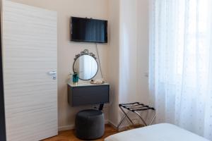 a bedroom with a mirror and a tv on the wall at B&B CASA PALMANOVA in Catania