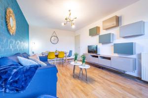ein Wohnzimmer mit einem blauen Sofa und Stühlen in der Unterkunft The Graphic Condo - Fairytale Factory in Lognes