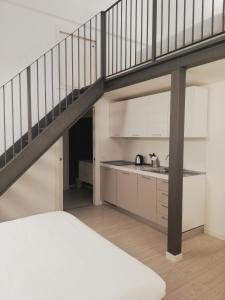 
a staircase leading up to a kitchen with a balcony at BB Hotels Aparthotel Città Studi in Milan
