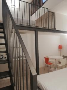 
a room with a table, chairs, and a staircase at BB Hotels Aparthotel Città Studi in Milan
