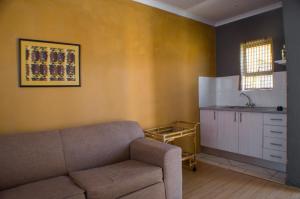 a living room with a couch and a kitchen at Seroloana Guest House in Rustenburg