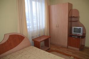 a bedroom with a bed and a tv on a cabinet at Yasin-Svit in Yasinya