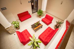 una vista panorámica de una sala de estar con sillas rojas y una mesa. en Hotel El Español Centro Historico en Mérida