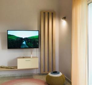 a living room with a flat screen tv on a wall at Aloni Studios and Apartments in Lassi