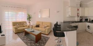 sala de estar con 2 sofás, mesa y cocina en Fournier Apartment - Praia da Luz, en Luz