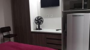 a kitchen with a white counter and a refrigerator at Flat em Cabo Frio in Cabo Frio