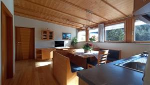 a kitchen and living room with a table and chairs at Haus Bergfrieden in Castelrotto