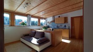 a living room with a couch and a kitchen at Haus Bergfrieden in Castelrotto