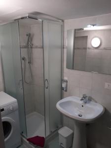baño blanco con ducha y lavamanos en Il Leoncorno en Ferrara