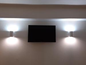 2 luci su una parete con TV a schermo piatto di Il Leoncorno a Ferrara