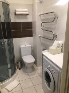 a bathroom with a toilet and a washing machine at Kranto Luxe Stay in Panevėžys