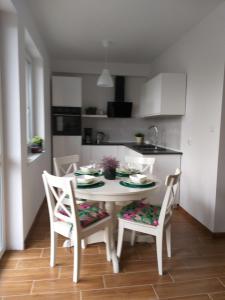 a kitchen with a white table and chairs in a room at Rowy Apartament.b5 in Rowy