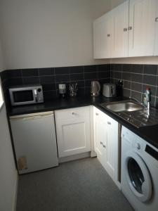 uma cozinha com um lavatório e uma máquina de lavar roupa em The Annexe em Bournemouth