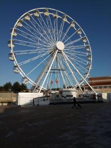 a large ferris wheel with a person walking past it at The Annexe in Bournemouth