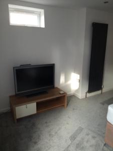 sala de estar con TV de pantalla plana sobre una mesa en The Annexe en Bournemouth