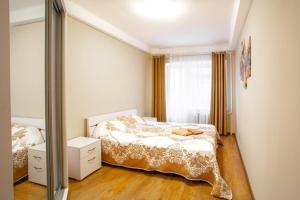 une chambre avec un lit et un miroir dans l'établissement Квартира поруч із Палацом Україна та Ocean Plaza, à Kiev