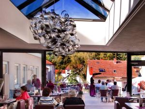 un restaurante con mesas y una lámpara de araña en Gästehaus Eschers Eiswerk, en Annweiler am Trifels