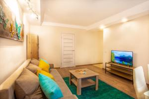 un salon avec un canapé et une télévision dans l'établissement Квартира поруч із Палацом Україна та Ocean Plaza, à Kiev