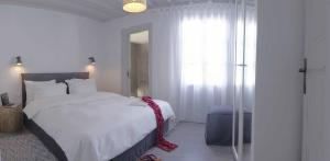 a bedroom with a white bed with a red ribbon on it at Mykonos Loft in Mikonos