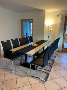 ウンターアンマーガウにあるFerienwohnung mit Bergblickのダイニングルーム(木製テーブル、黒い椅子付)