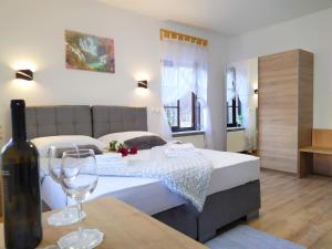 a bedroom with a bed and a bottle of wine at Plitvice Streaming in Prijeboj
