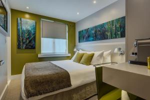
a bedroom with a large bed and a painting on the wall at Hotel 55 in London
