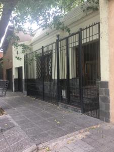 una cerca negra frente a una casa en Casa cerca del centro Bed&breakfast en Mendoza
