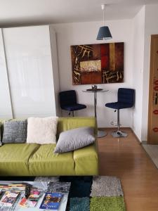 - un salon avec un canapé vert et 2 chaises dans l'établissement 1,5 szobás lakás terasszal,közel a Széchenyi fürdőhöz, à Budapest