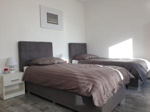 um quarto com 2 camas e uma mesa com um candeeiro em Apartment Evie - Central Historical Quarter em Rijeka