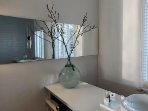 a vase with branches in it sitting on a counter in a bathroom at B&B Hart van Leiden in Leiden +11 photos
