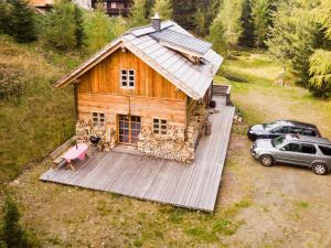 einen Luftblick auf ein Holzhaus und ein Auto in der Unterkunft Almhütte Chalet HIRSCHFISCH in Bodensdorf