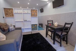 a living room with a couch and a dining room table at Central Praia Beach in Praia da Vitória