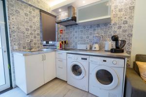 a kitchen with a washer and dryer in a room at Central Praia Beach in Praia da Vitória +8 photos