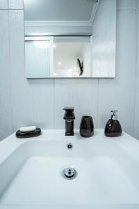 a bathroom with a sink with a mirror and a mirror at Central Praia Beach in Praia da Vitória