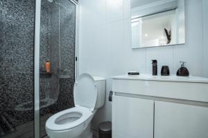 a white bathroom with a toilet and a shower at Central Praia Beach in Praia da Vitória
