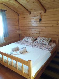 a bed in a log cabin with two phones on it at Etno selo Koljeno in Andrijevica