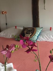 a picture of a dog on a bed with flowers at PuurTeuven B&B tussen Kunst en Natuur in Voeren