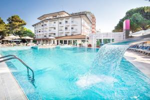 una piscina con un tobogán de agua frente a un hotel en Hotel Bristol, en Lignano Sabbiadoro