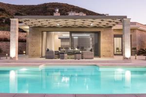 a swimming pool in front of a house at Larimar Luxury Sea View Villa in Kissamos