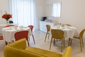 a dining room with two tables and chairs and a kitchen at B&B CASA PALMANOVA in Catania