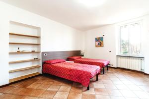 2 Betten in einem Zimmer mit roter Bettwäsche in der Unterkunft Il Roseto di Marina in Lucino