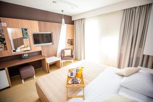 Cette chambre comprend un lit, un bureau et une télévision. dans l'établissement Hotel Herceg, à Međugorje